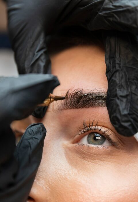 young-woman-getting-beauty-treatment-her-eyebrows young-woman-getting-beauty-treatment-her-eyebrows